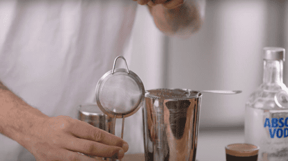 Double straining cocktails with a Hawthorne strainer and fine mesh strainer