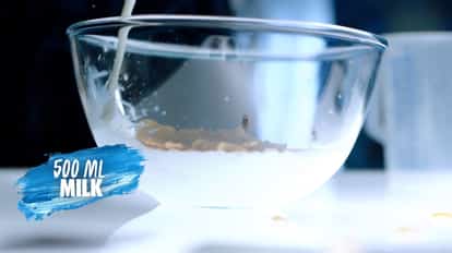 Adding milk into a glass bowl to make Warhol's Milk Punch