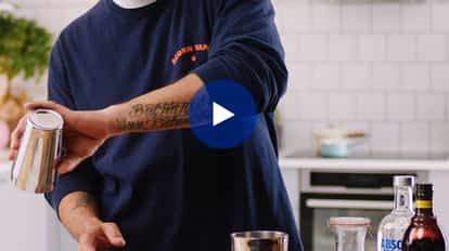 Rico demonstrating how to measure "parts" for a cocktail.