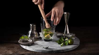 Wooden muddler to muddle cocktail ingredients including mint leaves for a Mojito.