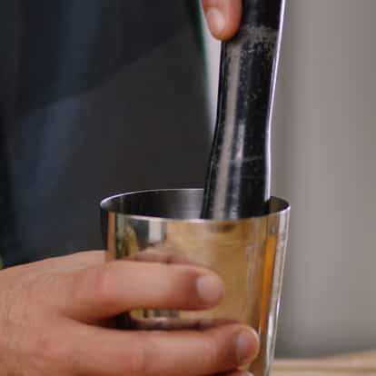 Muddling ingredients in a Boston Shaker.