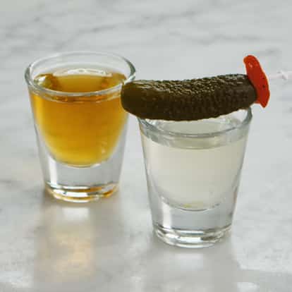 Two shots representing the Pickleback, one with Jameson irish Whiskey, the other with pickle juice.