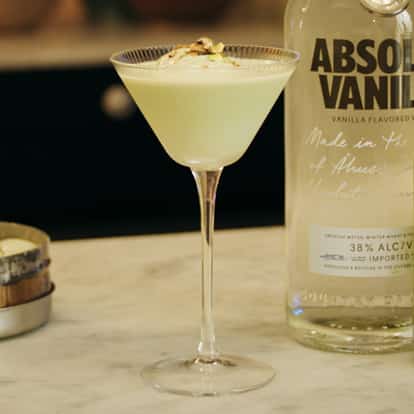 Pistachio Martini next to a bottle of Absolut Vanilia and pistachio cream liqueur.