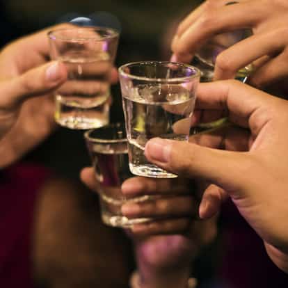 Barack Palinka served in several shot glasses held by hands