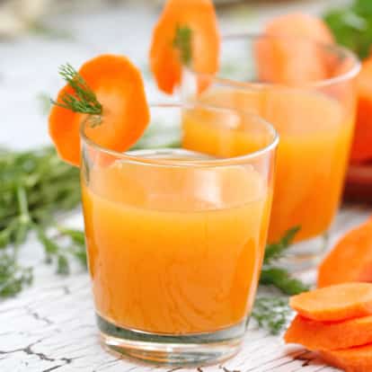 Carrot Juice in a rocks glass with a carrot slice garnish
