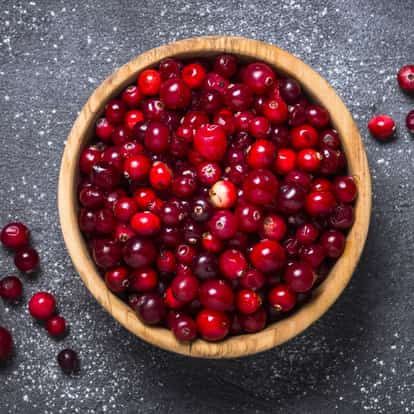 Cranberries in a wooden bowl on dark background