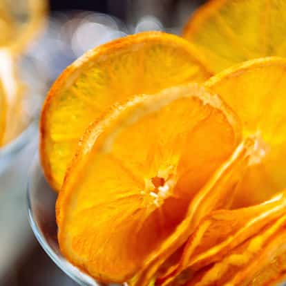 Dried tangerine slices in a glass bowl on blurred background