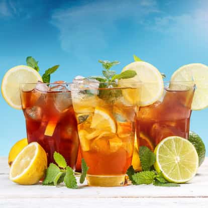 Mint Iced Tea served in three highball glasses with lemon slices and mint sprigs