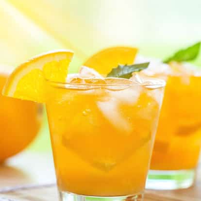 Orange Soda in two rocks glasses with ice and orange wedges