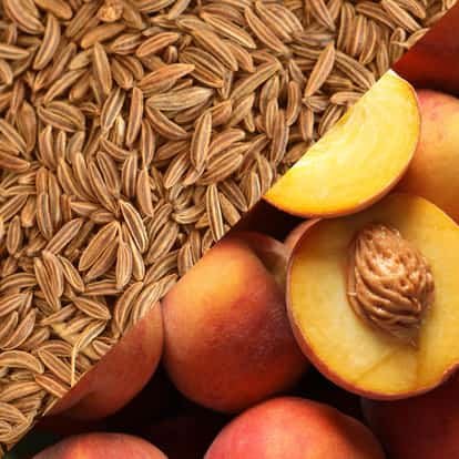 Peach and Caraway Syrup peach halves showing pit alongside a pile of caraway seeds