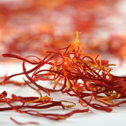 Saffron threads scattered on white background