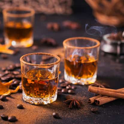 Spiced Rum in rocks glasses with cinnamon rims and coffee beans