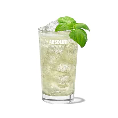 Absolut Basil in a highball glass with crushed ice and a basil sprig on white background