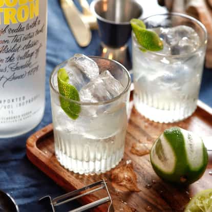 Citron Gimlet in a Rocks Glass next to a bottle of Absolut Citron vodka