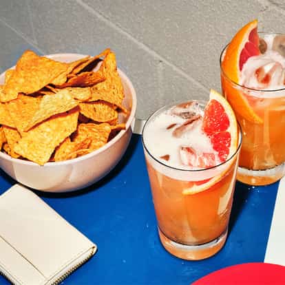 Absolut Fluffy Grapefruit served in two highball glasses with ice and foam, garnished with grapefruit wedges