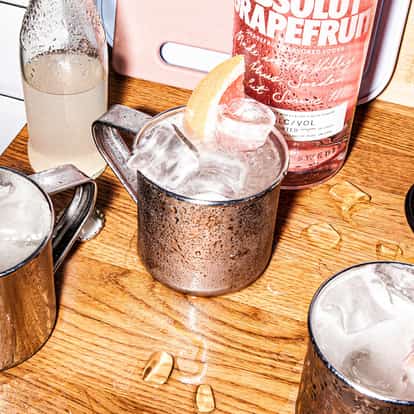 Three ice-filled aluminum mule mugs consisting of the Absolut Grapefruit Mule, a Moscow Mule varation that uses Absolut Grapefruit.