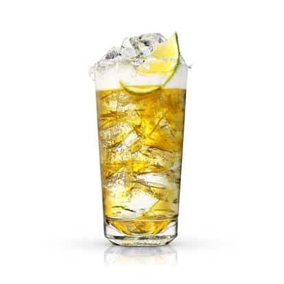 Absolut Michelada in a salt-rimmed highball glass with ice and a lime wedge on white background