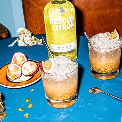 Absolut Passion Fruit rocks glasses of ice and passion fruit pulp with halved passion fruit