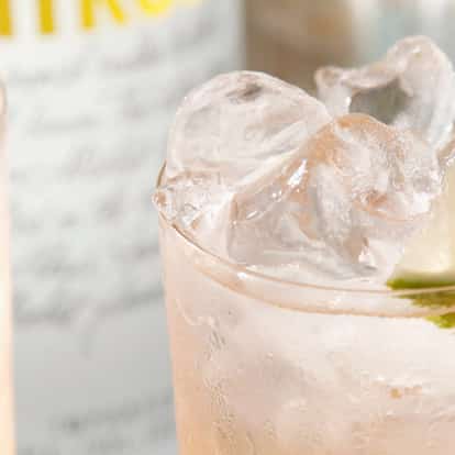 Absolut Passion in a highball glass filled with ice and garnished with a lime wedge