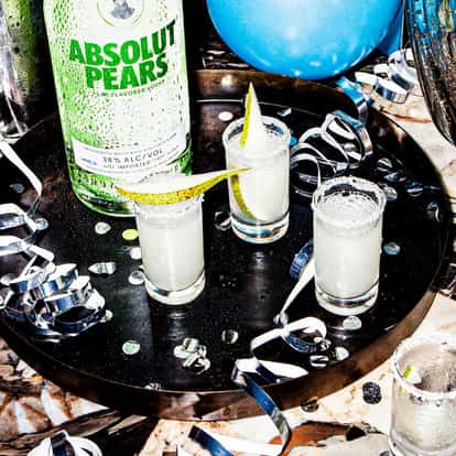Absolut Pear Drop shots next to a bottle of Absolut Pears Vodka