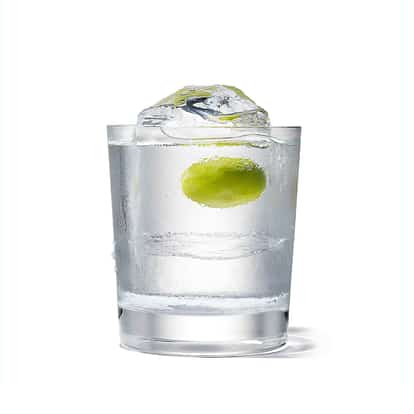 Absolut Rocks Martini in a rocks glass with a large ice dome and an olive on white background