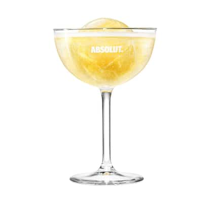 Sparkling Ice in an Absolut coupe glass with a lemon wheel on white background.