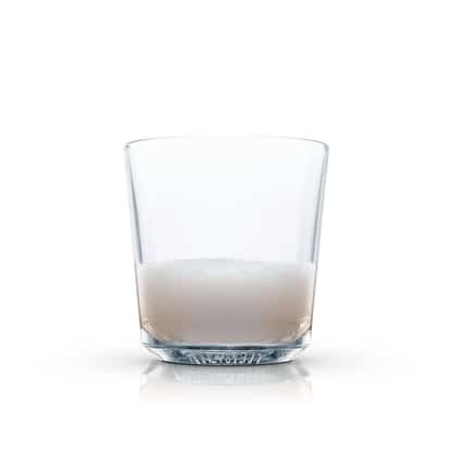Absolut Vanilia Coffee in a rocks glass with a shallow layer of liquid and foam on white background