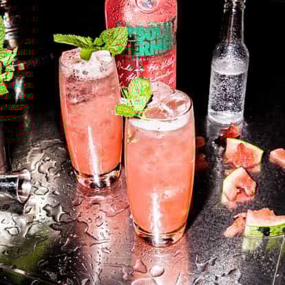 Absolut Watermelon Fizzy Punch next to a bottle of Absolut Watermelon and fresh mint.