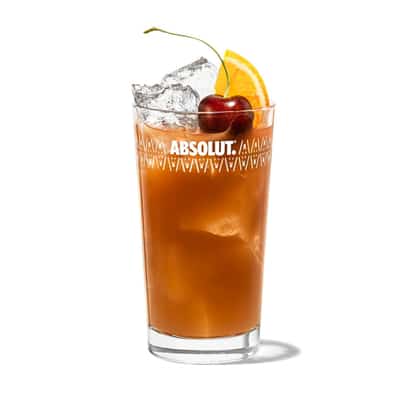 Tall iced cocktail with cherry and orange wedge in an Absolut highball glass on white background.