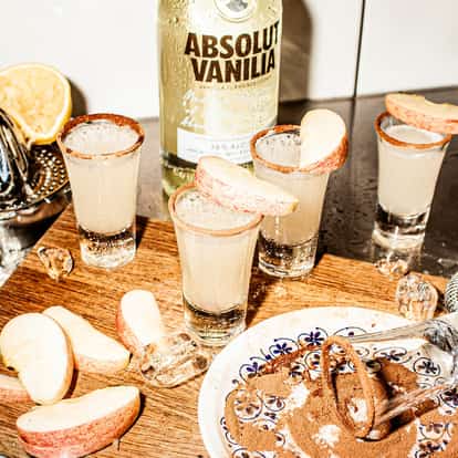 Apple Pie Shots next to a bottle of Absolut Vanilia vodka.