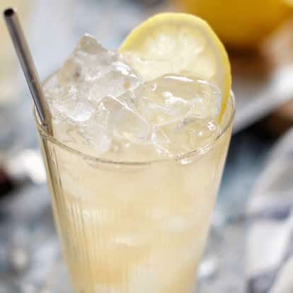 Arnold Palmer in a tall glass with crushed ice, metal straw and lemon wheel