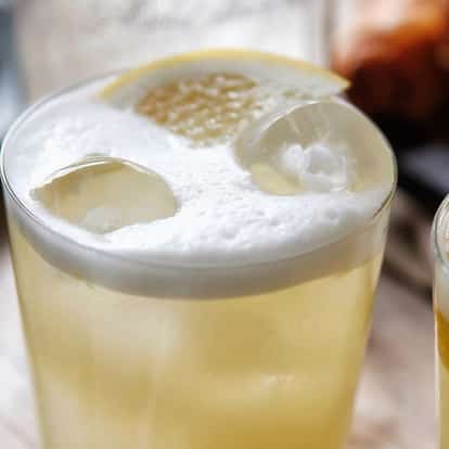 Bakery Sour in a rocks glass with foamy top, lemon slice and ice cubes