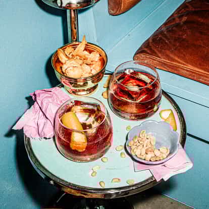Boulevardier cocktails made with Bourbon, Orange Bitter Italian Liqueur and Red Vermouth in two Rocks Glasses.