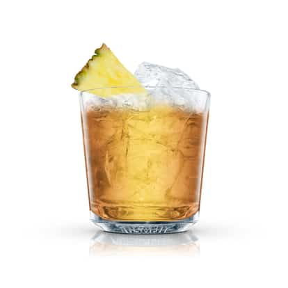 Buster in an Absolut rocks glass with ice and a pineapple wedge on white background