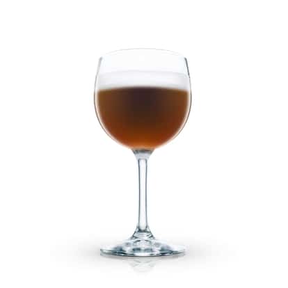 Calypso Coffee de Lux served in a stemmed wine glass with foam on white background