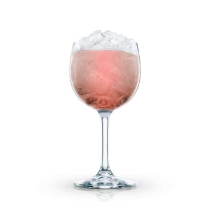 Claret Fizz in a stemmed wine glass topped with crushed ice on white background