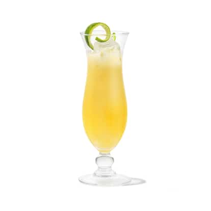 Coconut Colada Grove served in a hurricane glass with crushed ice and a lime twist on white background