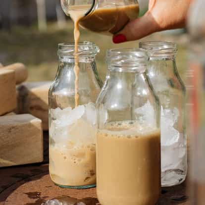 Colorado Bulldog in three small glass bottles with ice being poured into one