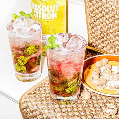 Cosmojito in two highball glasses with mint sprigs and an Absolut Citron bottle in the background