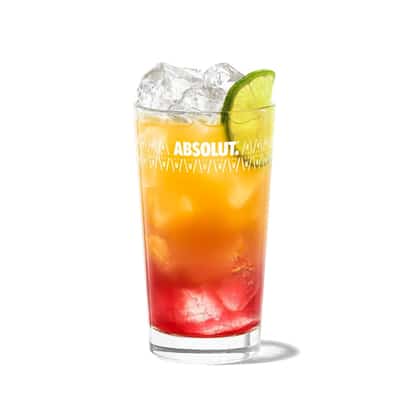 Cracker in an Absolut highball glass with ice and lime wedge on white background