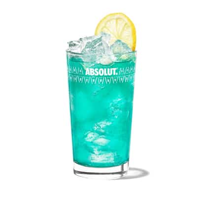 Cupids Blue is in an Absolut highball glass with ice and a lemon wheel on white background.