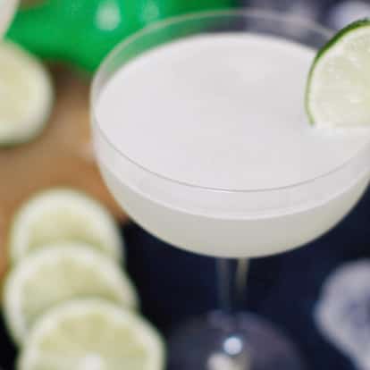 Delicious Daiquiri cocktail surrounded by lime wheels.