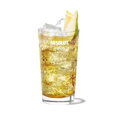 Dandy Shandy in an Absolut highball glass with ice and pear wedge on white background