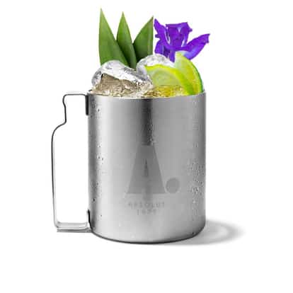 Desert Mule in an Absolut mug with ice and lime wedges, pineapple leaves and a flower