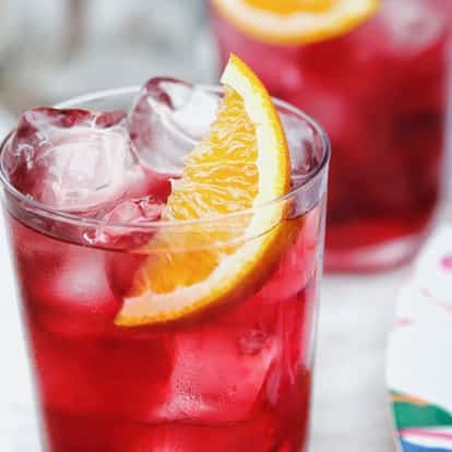 Easy Breeze in a clear highball glass with ice and an orange wedge.