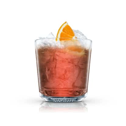 Pink iced cocktail in an Absolut rocks glass with an orange wedge on white background.