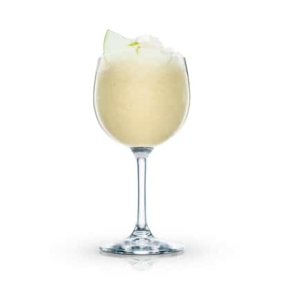 Frozen Apple served in a stemmed wine glass with crushed ice and apple wedge garnish on white background