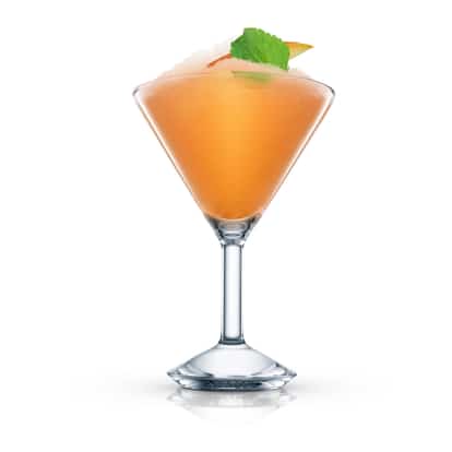 Frozen Mango And Mint Spiced Daiquiri in an Absolut martini glass garnished with a mint leaf on white background.
