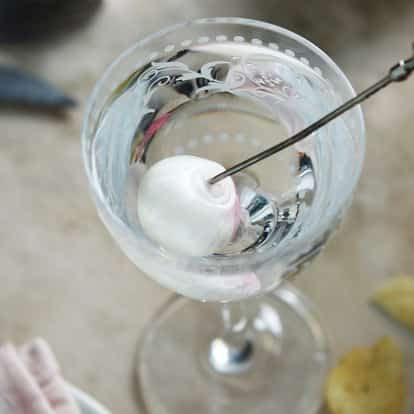 Gibson in an etched stemmed glass with a pearl onion on a metal pick