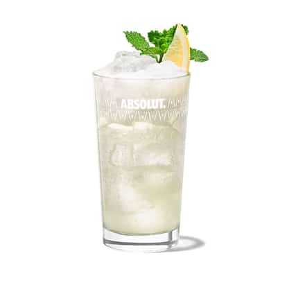 Gin Fizz in an Absolut highball glass with crushed ice, lemon wedge and mint sprig on white background